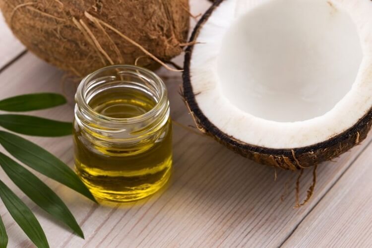 Coconut half and jar of oil